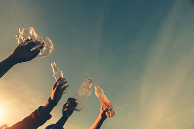 Low angle view of people hand against sky