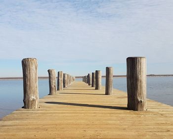 Wooden pier on sea against sky