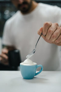 Man pouring coffee in cup on table