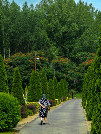 Rear view of person riding bicycle on road