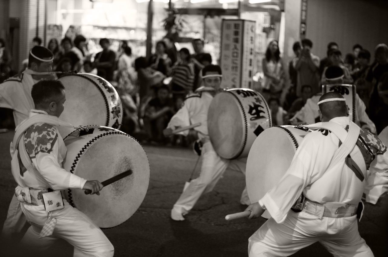 indoors, men, large group of people, arts culture and entertainment, lifestyles, focus on foreground, leisure activity, person, music, technology, rear view, crowd, incidental people, sitting, photography themes, performance, hat, casual clothing, musical instrument