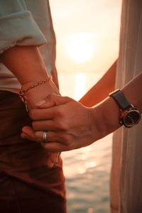 Midsection of couple holding hands