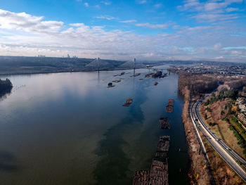 High angle view of city by mountain against sky