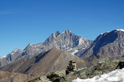 Scenic view of majestic mountain range against clear blue sky