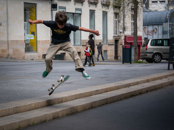 Full length of man skateboarding in city