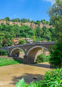 Arch bridge over river against sky