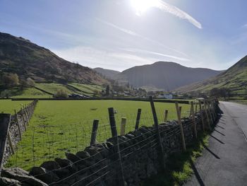 Scenic view of field and mountains against sky