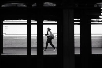 Side view of woman walking through window