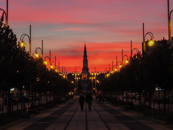 Illuminated buildings against sky during sunset