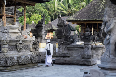 Rear view of man walking towards temple