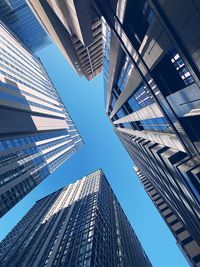 Low angle view of modern buildings against clear blue sky