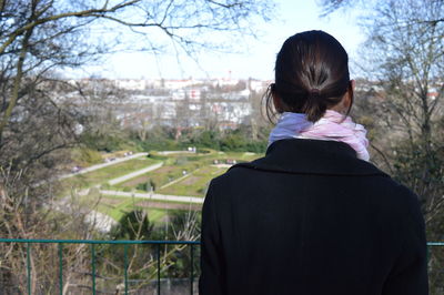 Rear view of woman standing by railing