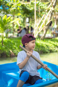 Boy rowing boat in water