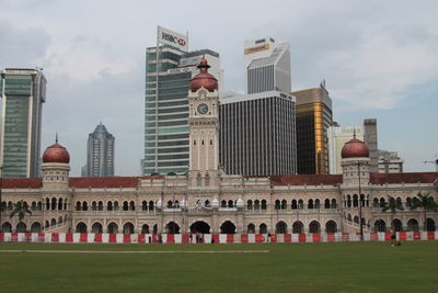 Buildings in city against cloudy sky