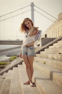 Young woman standing on staircase