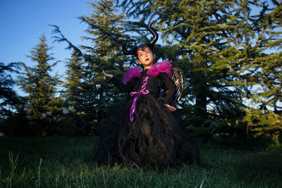 Girl with maleficent costume playing in the woods