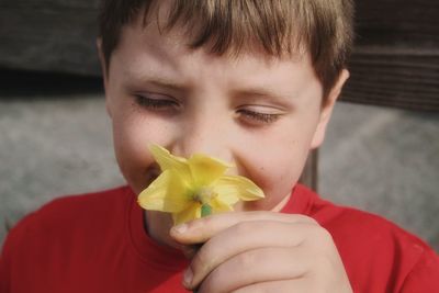 Close-up portrait of boy holding flower