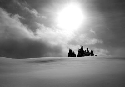 Silhouette people on snow covered landscape against sky