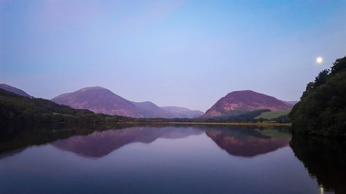 Scenic view of lake and mountains against clear sky