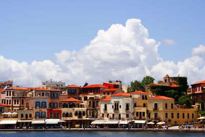 Buildings in town against cloudy sky