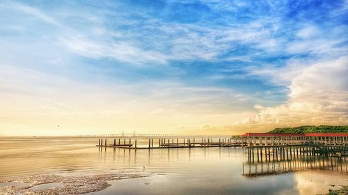 Pier over sea against sky during sunset