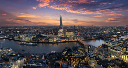 Aerial view of buildings against sky in city during sunset