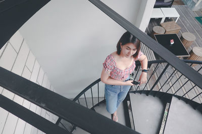 Portrait of smiling woman standing on staircase