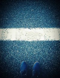 Low section of man standing on road