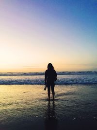 Silhouette of people on beach at sunset