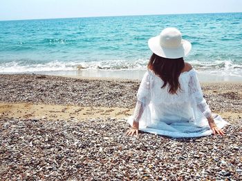 Full length of woman sitting on beach