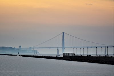 View of suspension bridge against cloudy sky