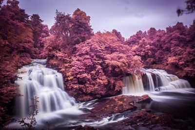 Scenic view of waterfall against trees