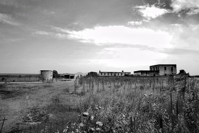 Abandoned building on field against sky