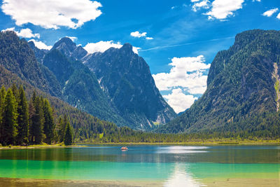 Scenic view of lake by mountains against sky