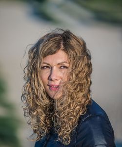 Portrait of smiling woman against blurred background