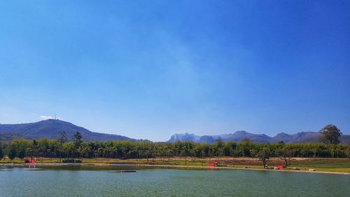 Scenic view of lake against clear blue sky