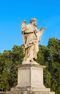 Low angle view of statue against blue sky