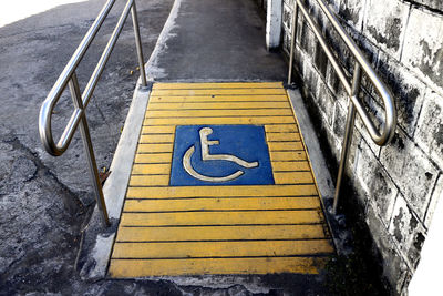 High angle view of arrow sign against blue sky