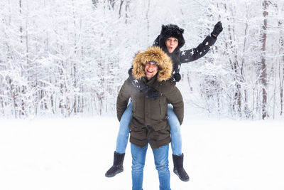 Portrait of woman standing on snow covered tree