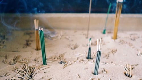 Burning incense sticks in container at temple