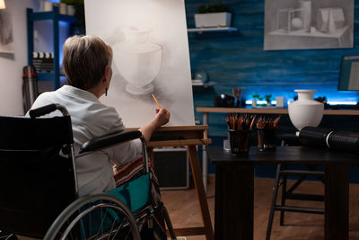 Rear view of woman sitting on table