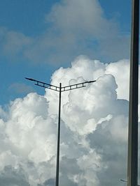 Low angle view of silhouette pole against blue sky