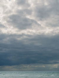 Scenic view of sea against storm clouds