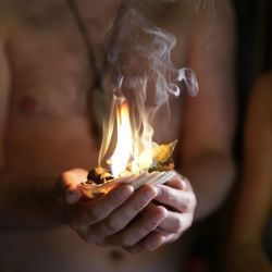 Close-up of man holding burning candle