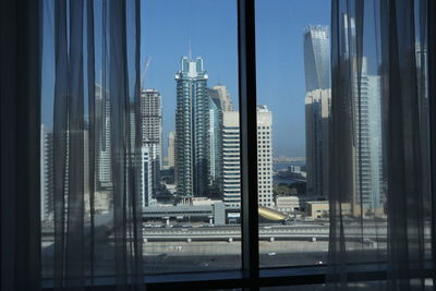 Modern buildings in city seen through glass window