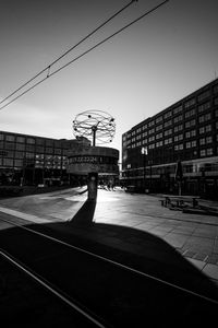 View of railroad tracks by buildings against sky