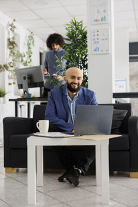 Side view of businessman using laptop at office