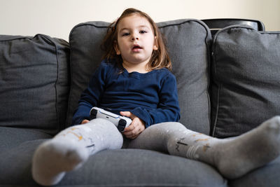 Full length of man sitting on sofa