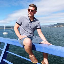 Portrait of young man sitting on boat sailing in sea