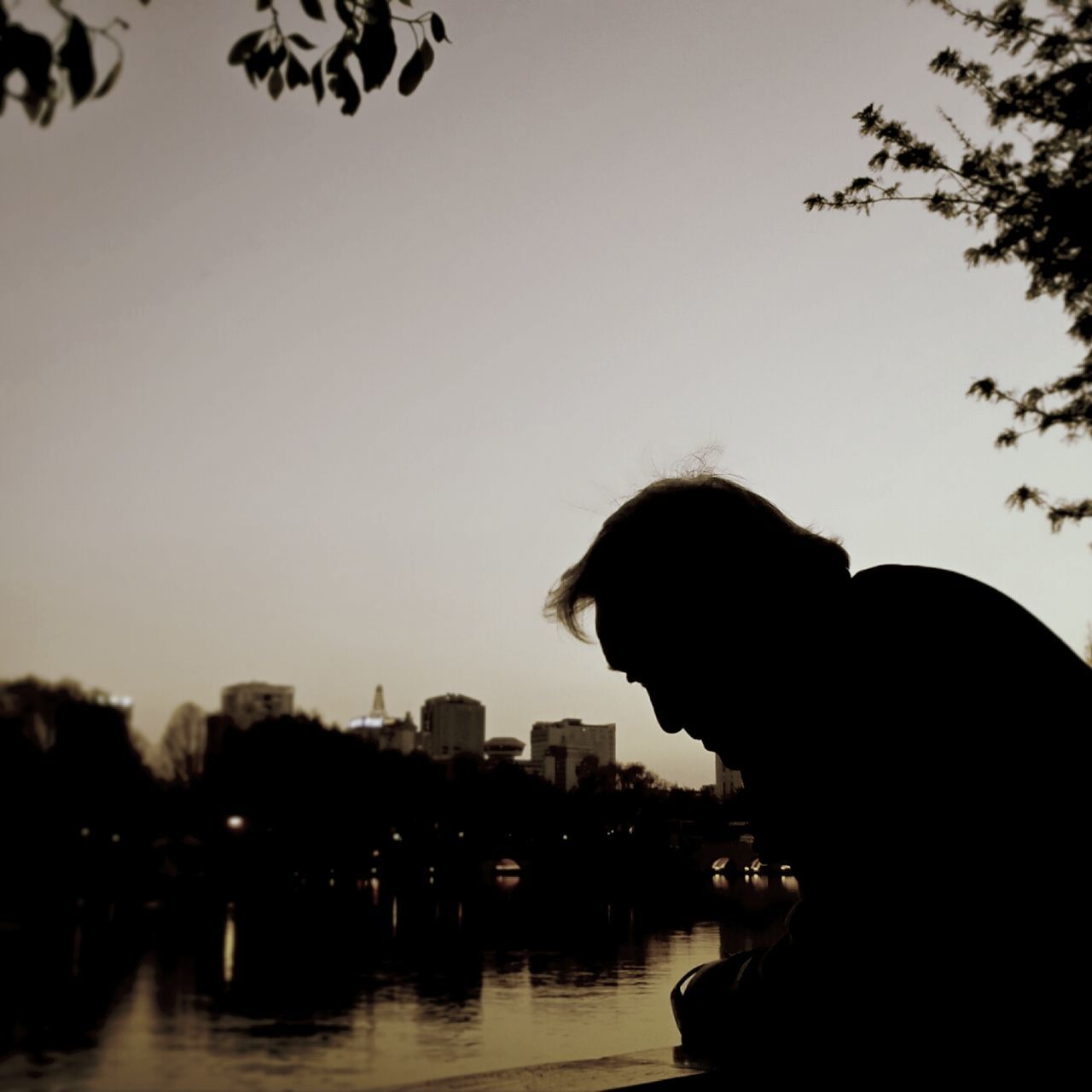 silhouette, clear sky, copy space, building exterior, architecture, built structure, lifestyles, city, leisure activity, rear view, sky, water, tree, person, dusk, men, headshot, sunset